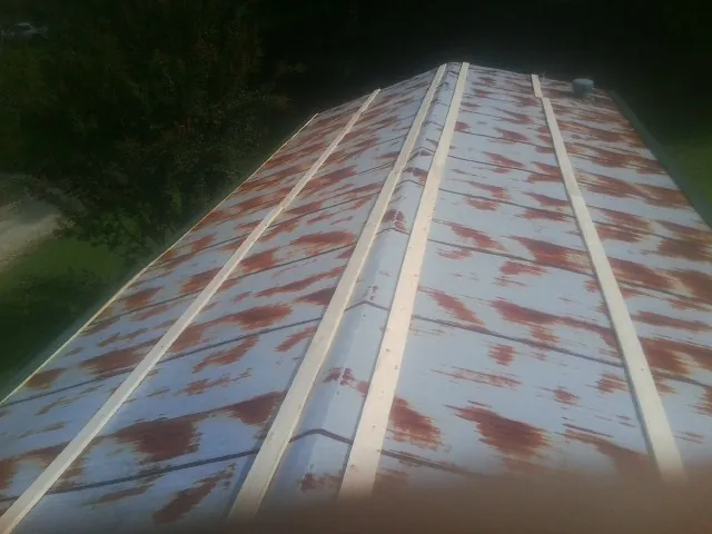 Rusted metal roof panels with new wood purlins before replacement — Storm Damage Roof Repair in Randleman by Roofing Brothers