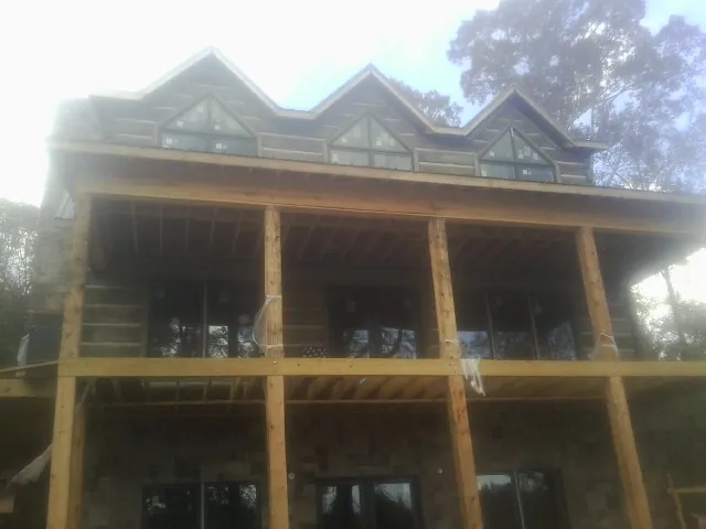 Dormers and porch framing on a large log home under construction — Roof Coating work by our crew in Randleman