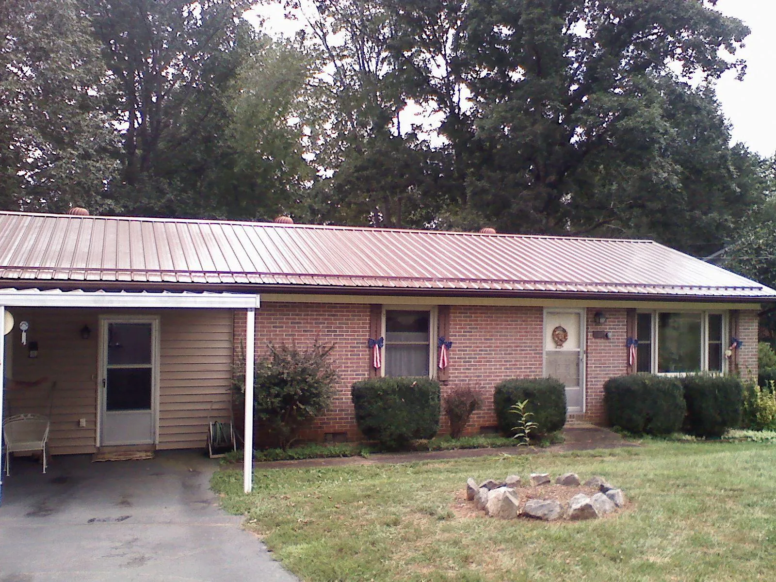 Bronze metal roof and carport on a brick ranch home — Roof Repair work by our crew in Randleman